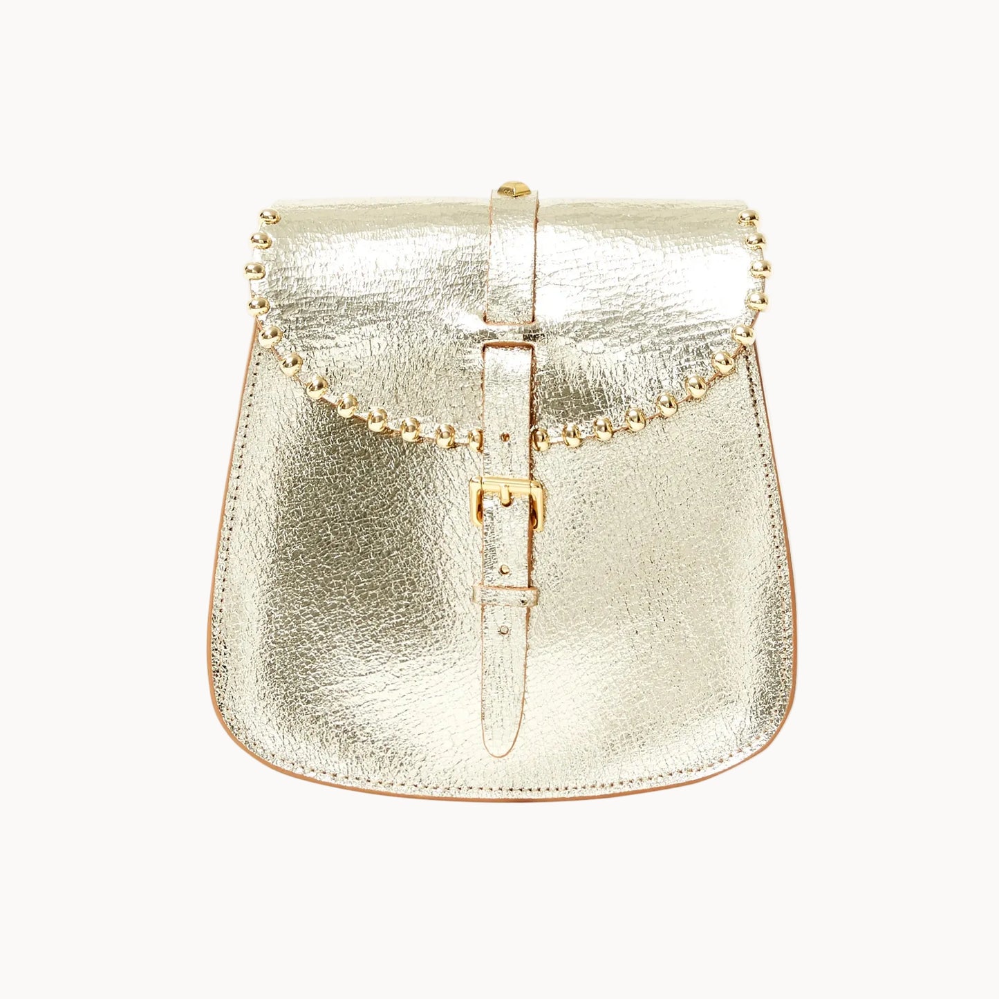 A metallic gold saddle bag with a textured leather finish, featuring a central buckle strap and beaded detailing across the top, set against a plain white background.