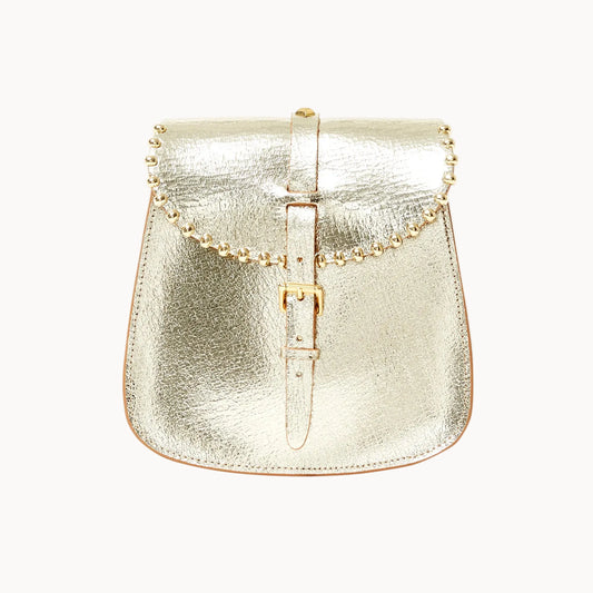 A metallic gold saddle bag with a textured leather finish, featuring a central buckle strap and beaded detailing across the top, set against a plain white background.