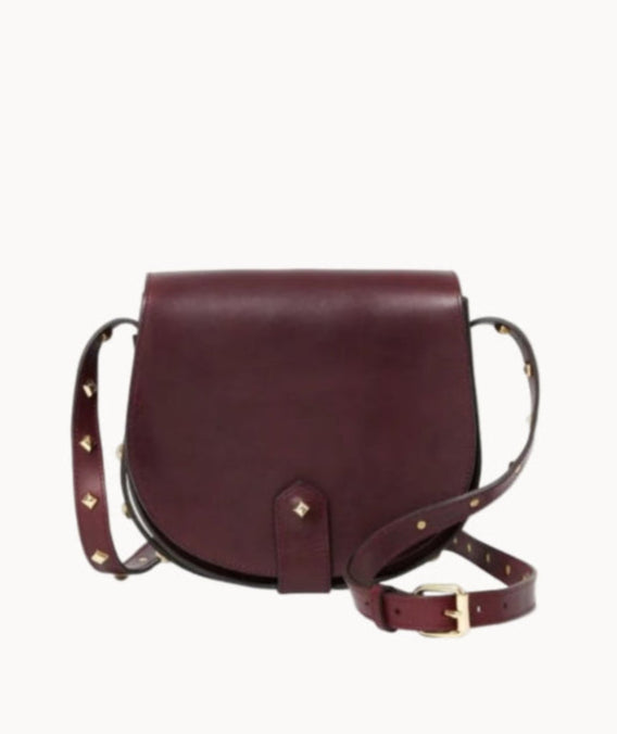 Burgundy leather handbag with brass stud accents on a light gray background