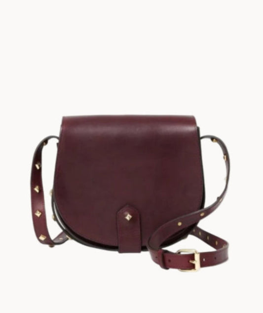 Burgundy leather handbag with brass stud accents on a light gray background