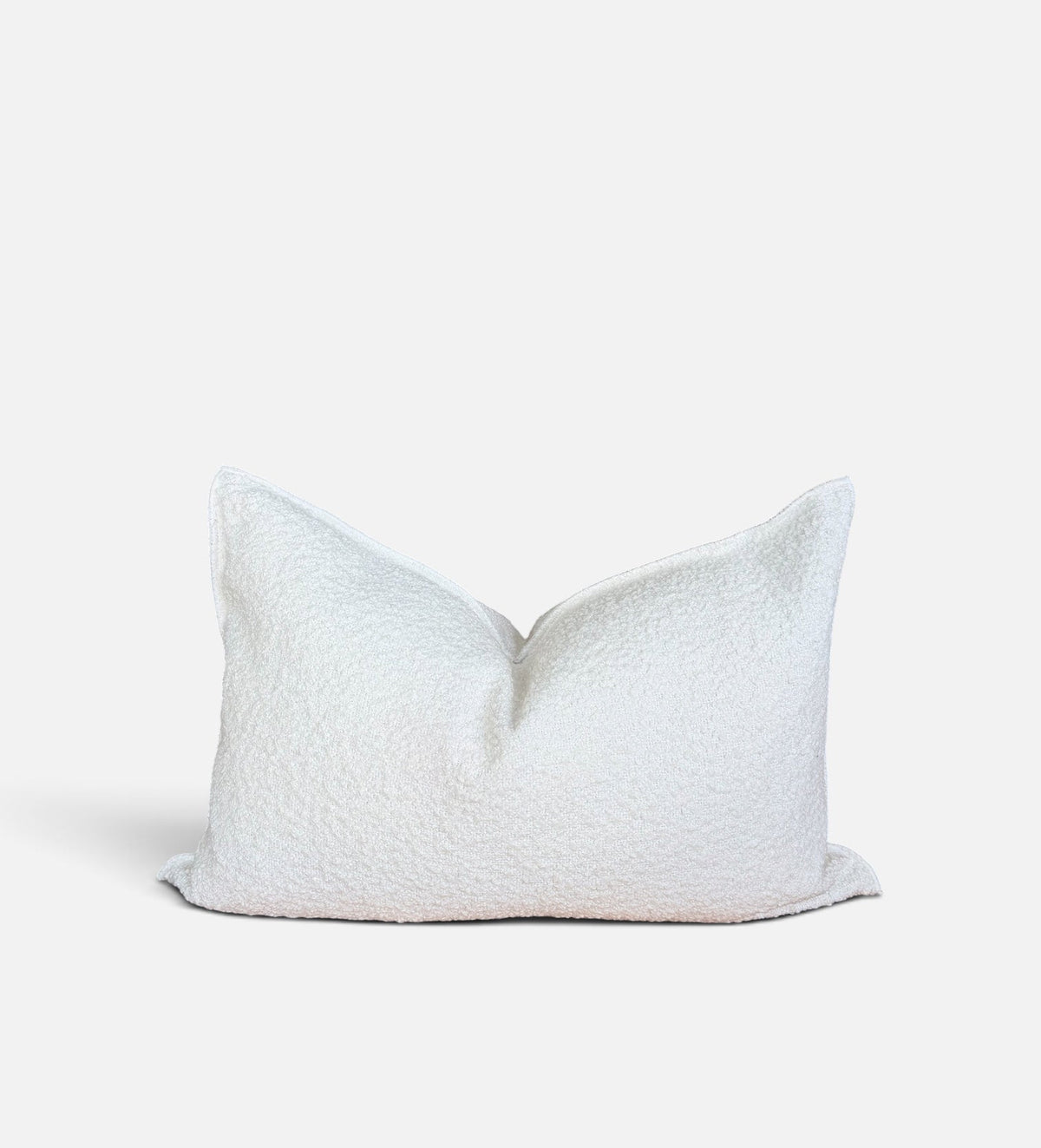 A rectangular white textured throw pillow with a soft, bouclé-like fabric, photographed against a clean white background.