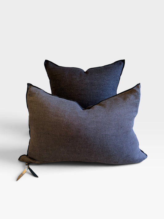 Two textured throw pillows in dark charcoal gray and black, arranged with one in front of the other on a clean white background.