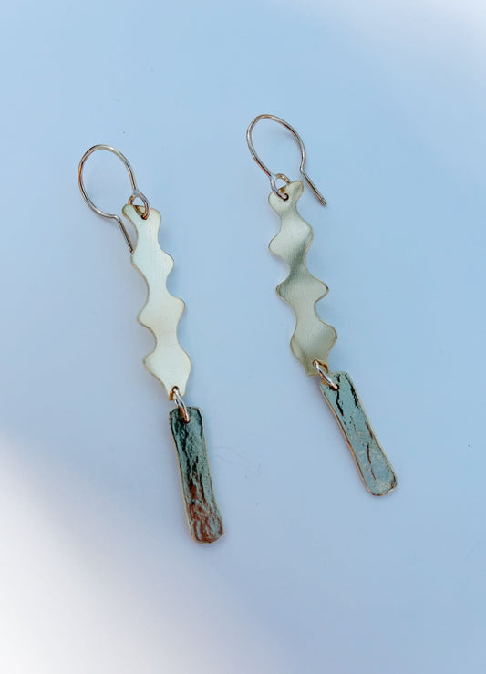 A pair of dangle earrings with silver-colored metal and hammer-textured details.
