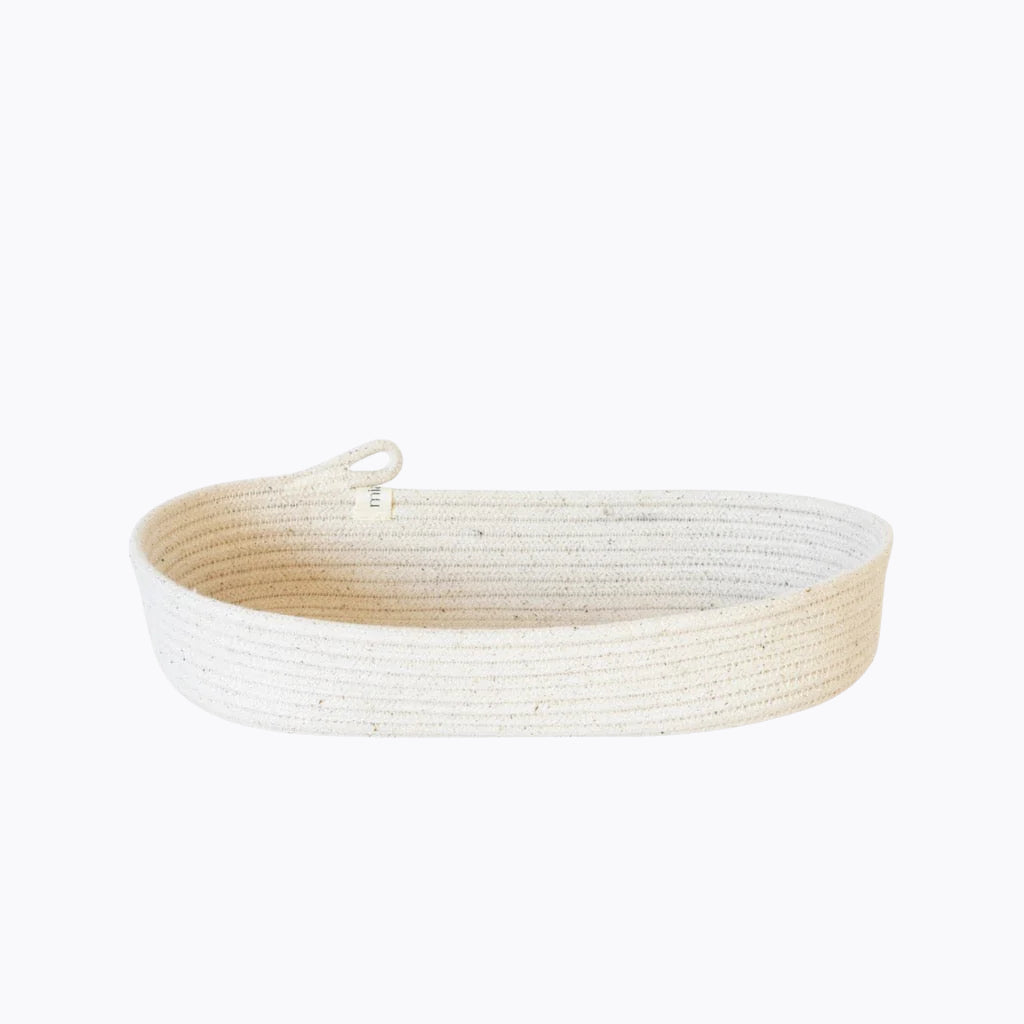 An oval rope basket made from natural cotton, featuring a sturdy handle.