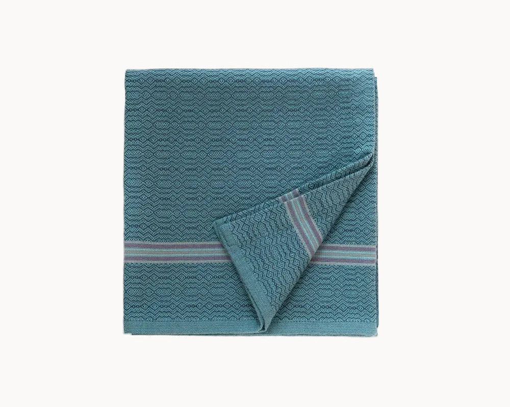 Teal=colored textured kitchen towel with a striped pattern on a white background