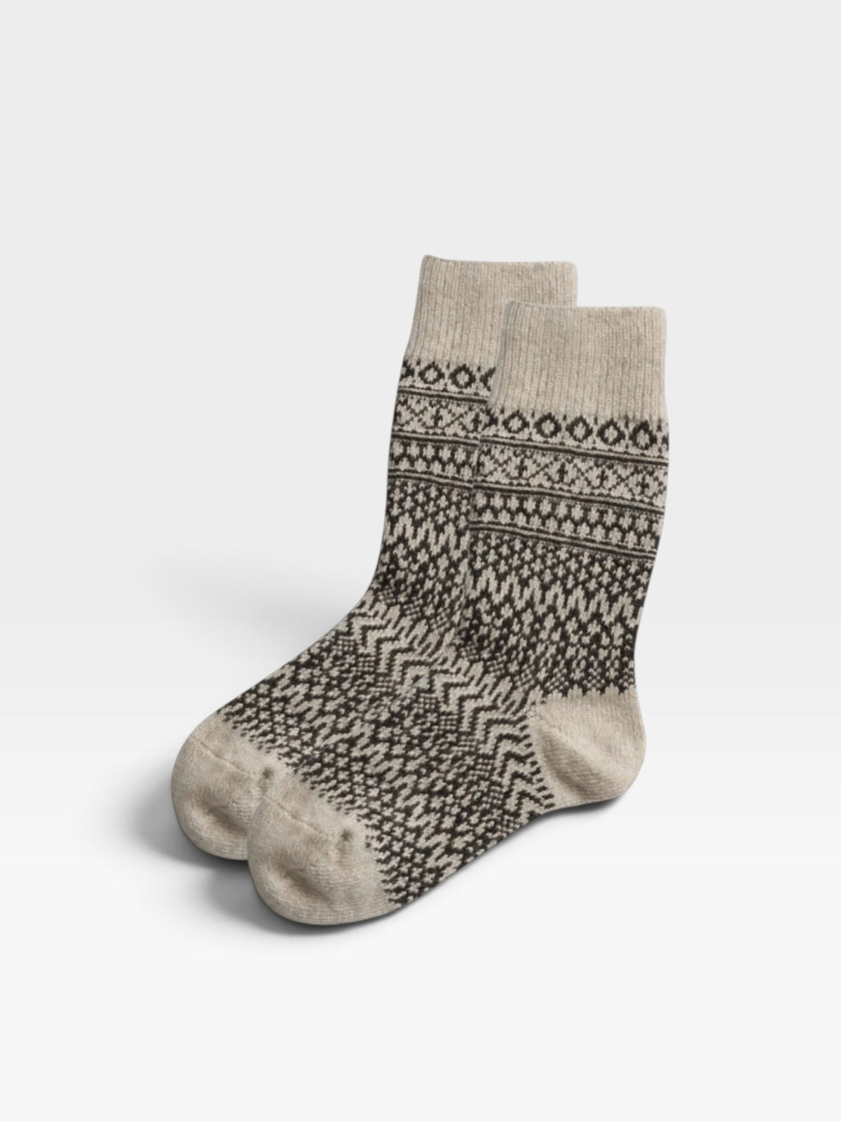 Pair of oatmeal-colored wool socks with a black jaquard design photographed against a white background