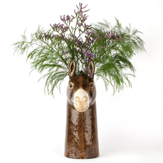 Donkey-shaped vase with floral arrangement on a white background
