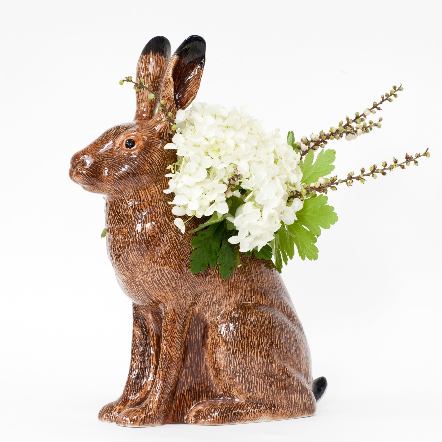 Decorative rabbit vase with a floral arrangement on a white background