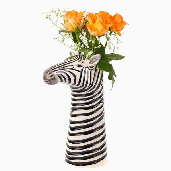 Zebra-shaped vase with orange flowers on a white background