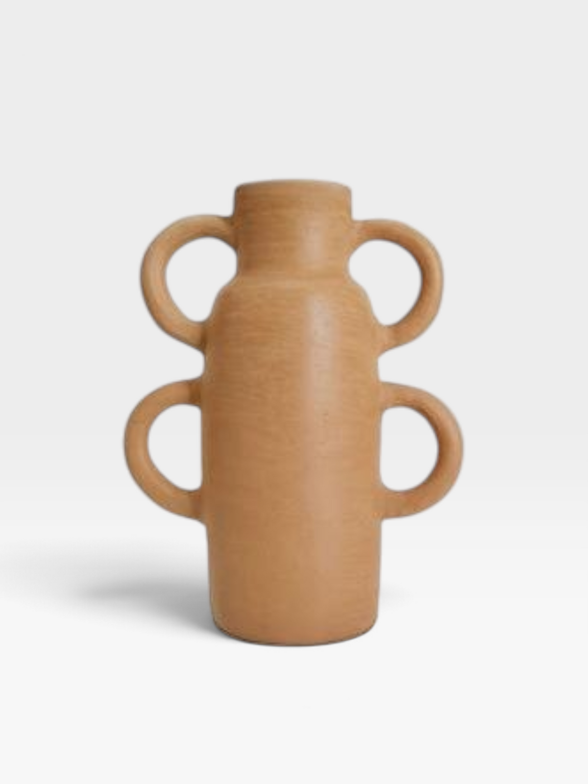 A tan colored ceramic clay vessel with a bottle shaped body and two half rings adorning each side set on a white background