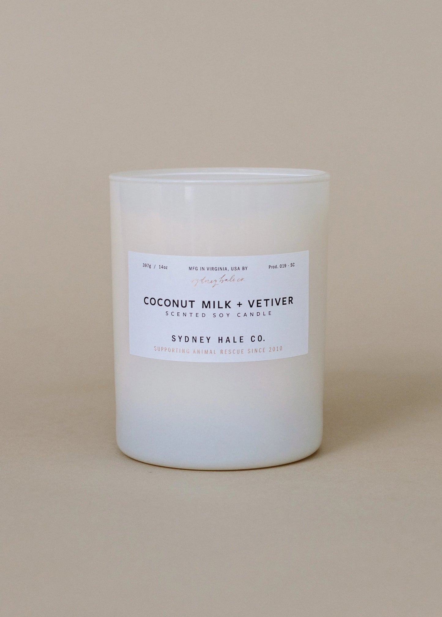 Coconut and milk vetiver candle on a beige background