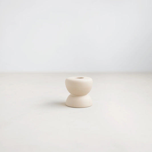White ceramic candle holder on a light gray background