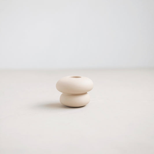 White ceramic vase with two stacked cylindrical shapes on a light gray background