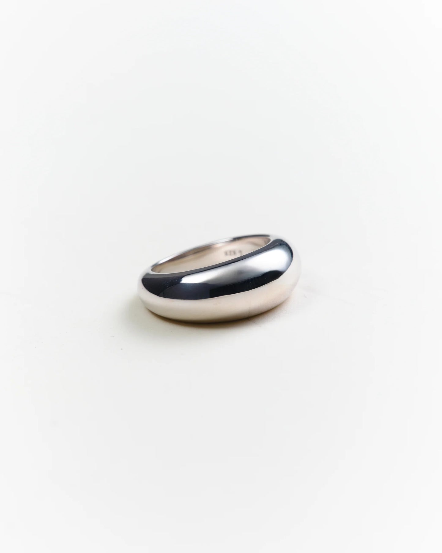 Silver ring on a light gray background