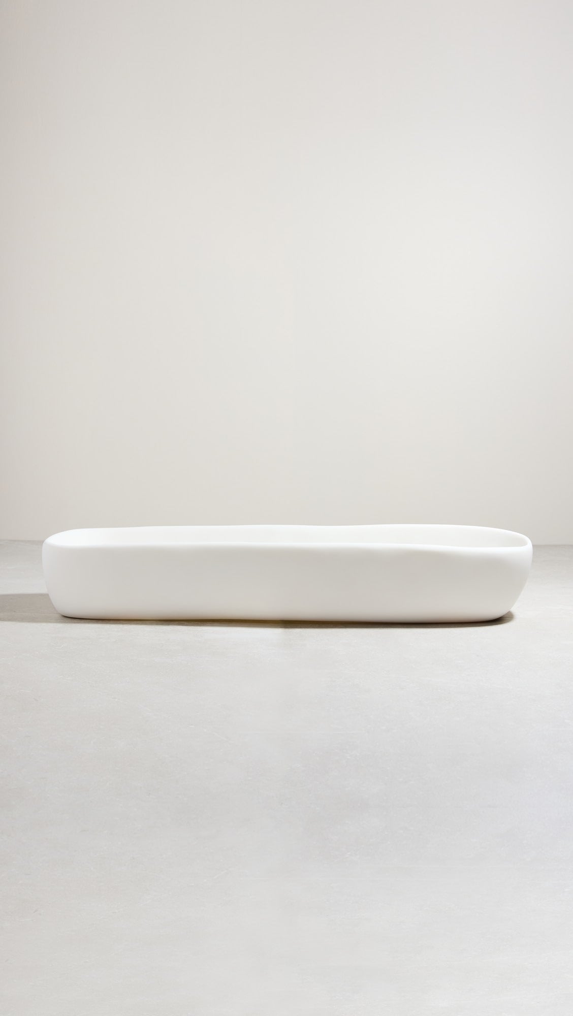 A white, hand-sculpted centerpiece bowl on a light background.
