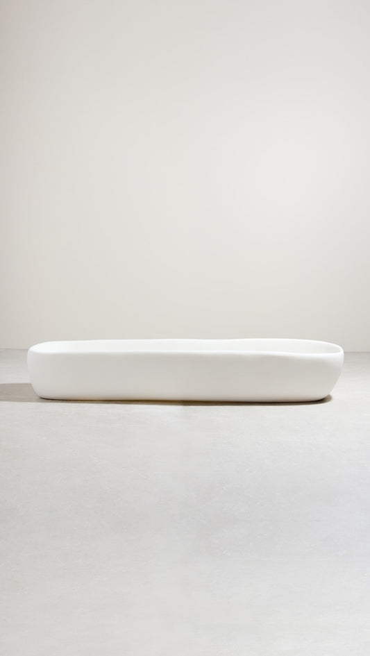 A white, hand-sculpted centerpiece bowl on a light background.