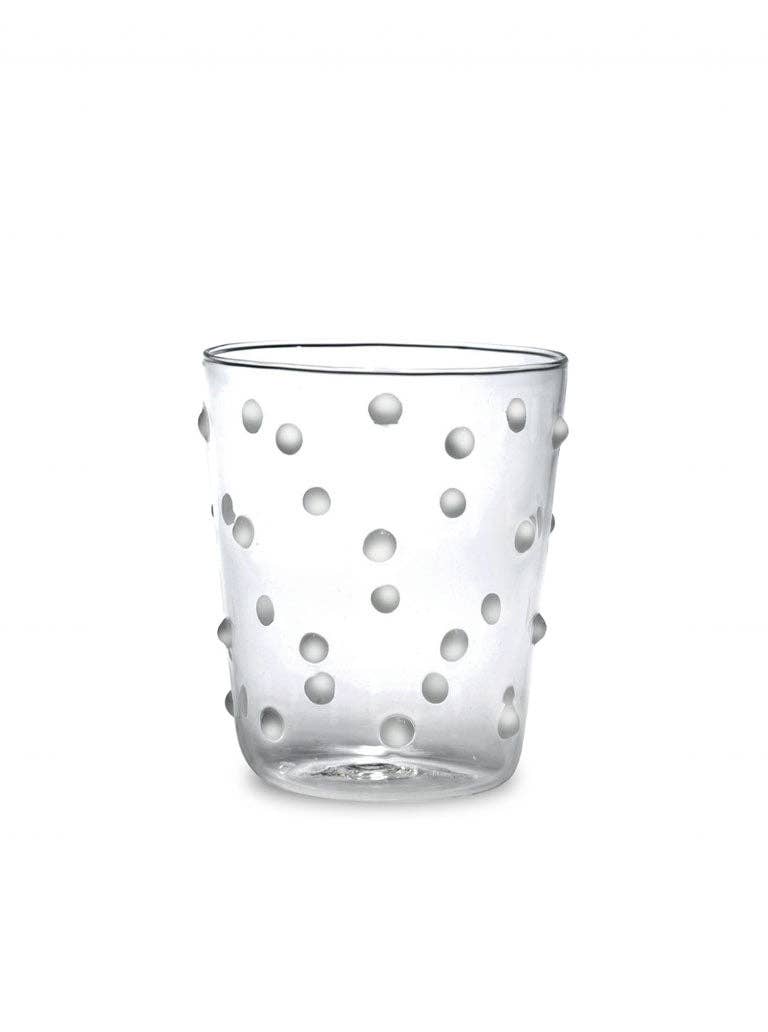 Clear glass tumbler with dot pattern on a white background