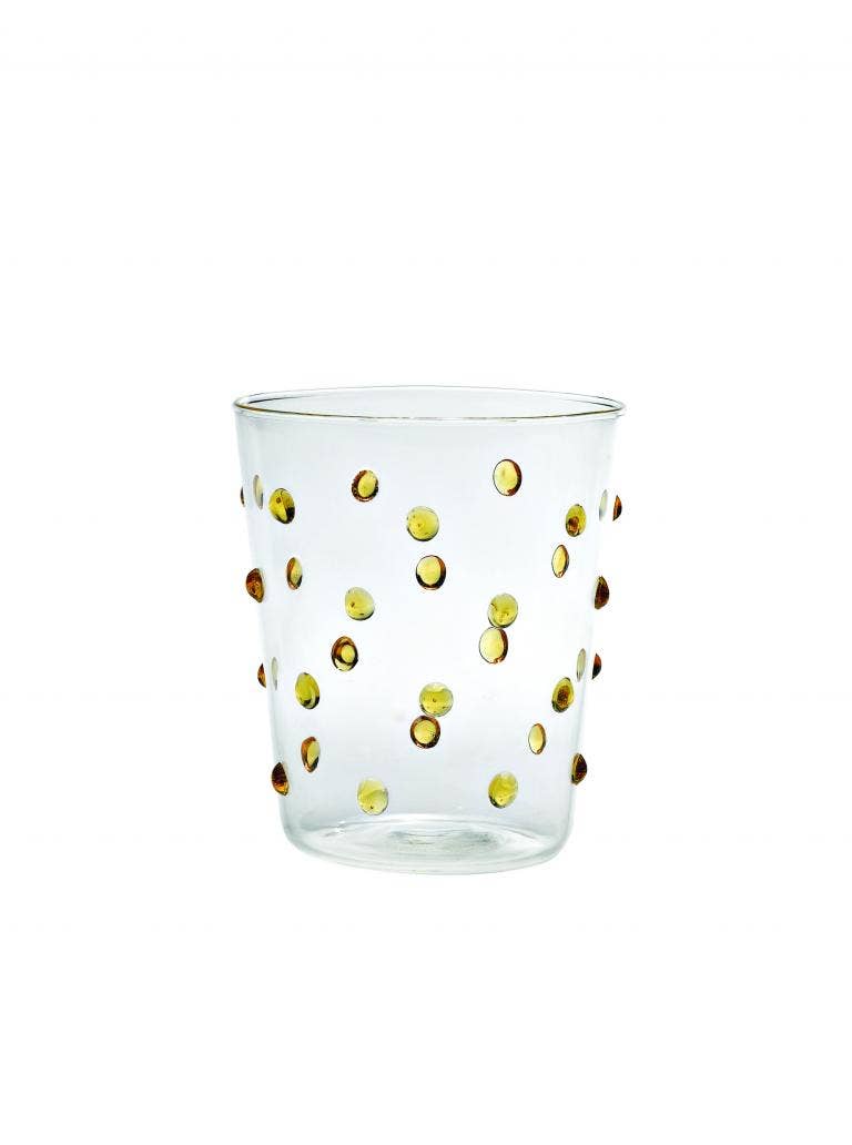 Clear glass tumbler with gold polka dots on a white background