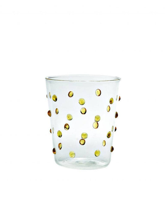 Clear glass tumbler with gold polka dots on a white background
