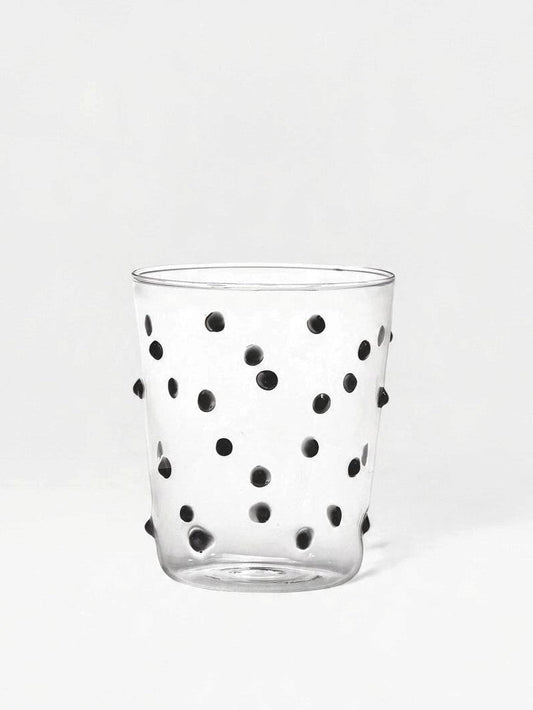 Glass tumbler with black dot detailing on a white backdrop