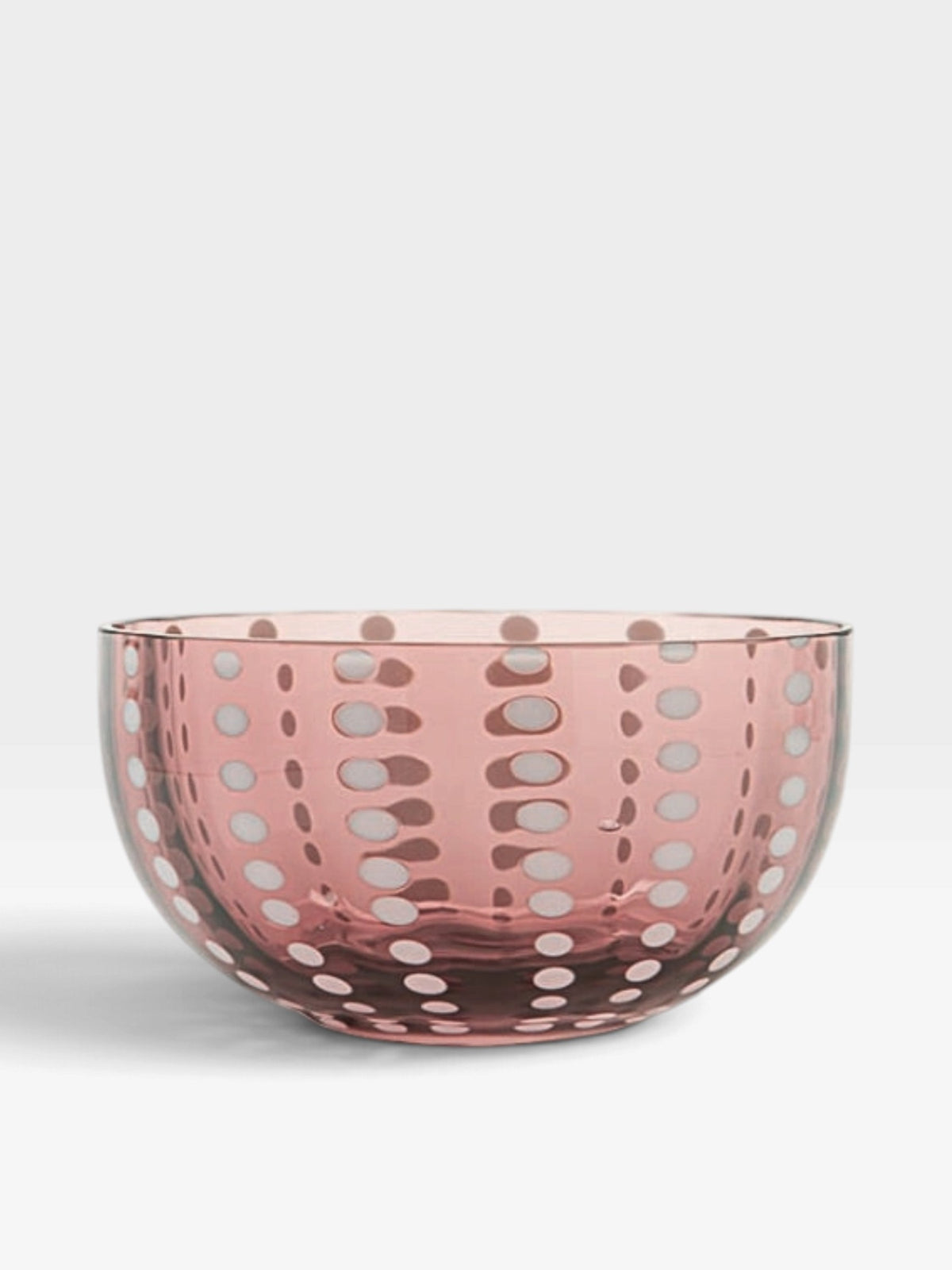 An amethyst-colored translucent glass bowl with a pattern of white polka dots, shown on a light gray background.