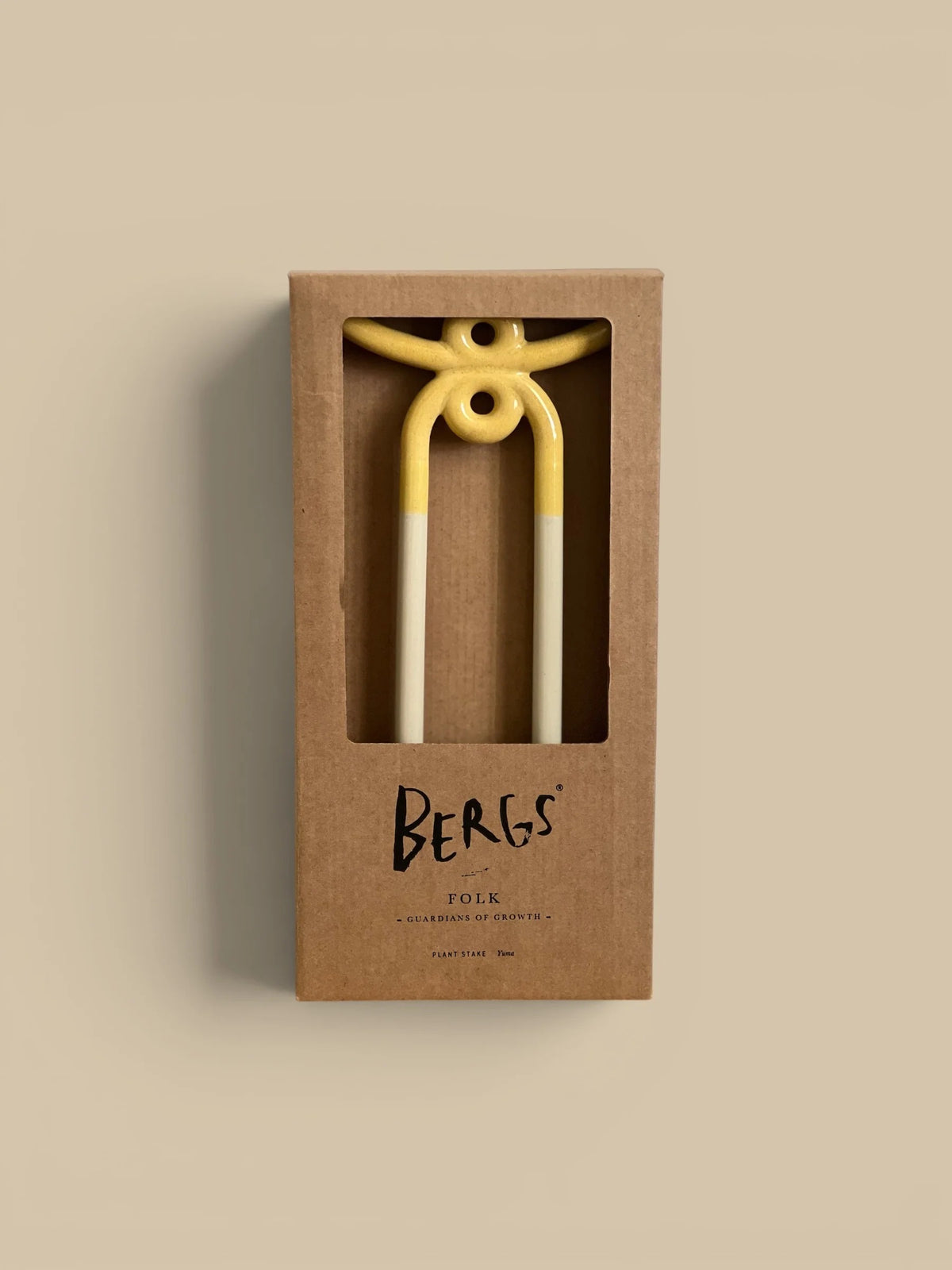 Yellow and white ceramic folk in a brown box with 'BERGS' branding on a beige background