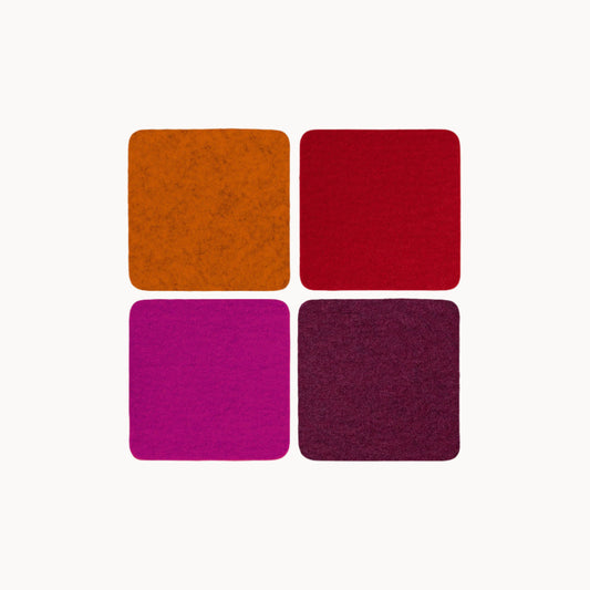 Four square wool felt coasters in orange, red, pink, and purple on a white background