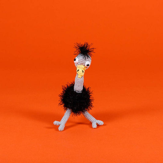 Knitted ostrich dog toy on an orange background