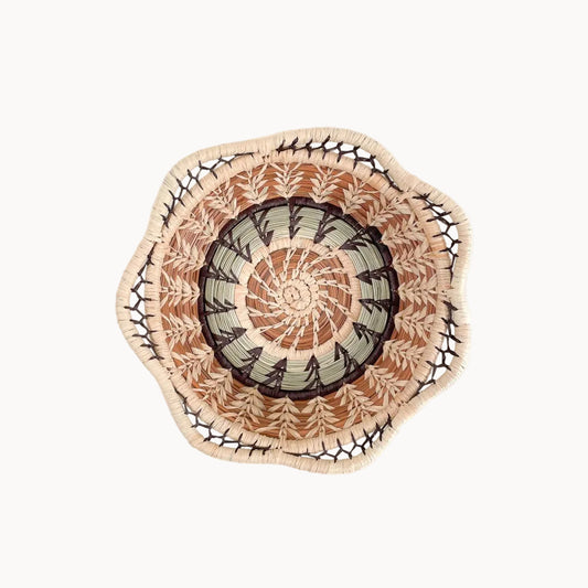 Decorative woven plate with a geometric pattern on a white background