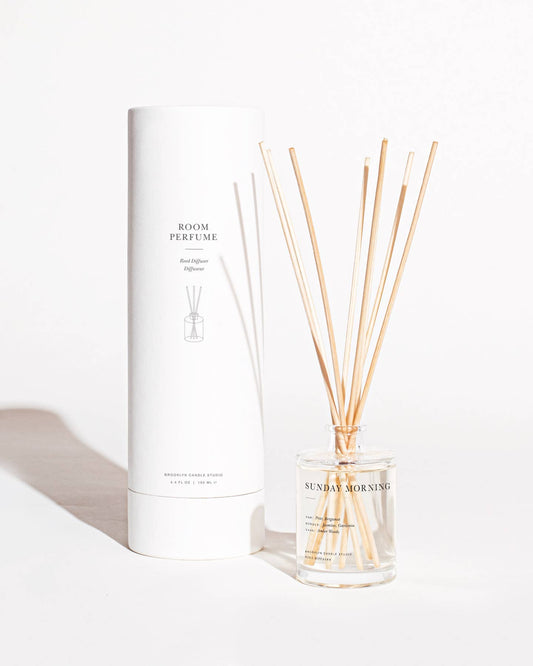 Sunday Morning scented reed diffuser in a glass bottle with wooden reeds on a white background