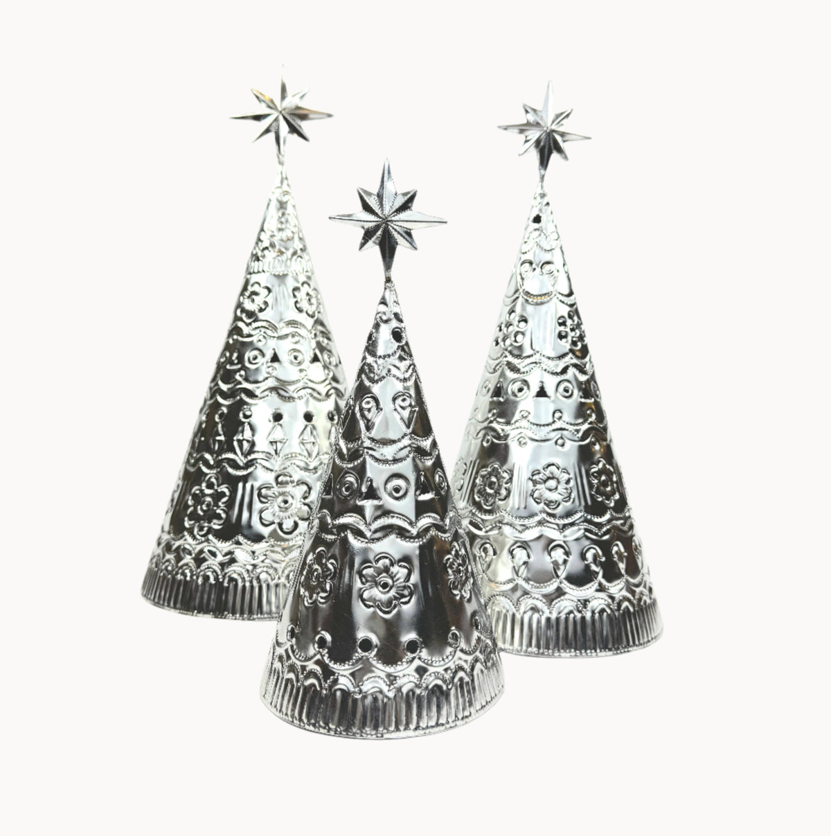 Three tabletop tin Christmas trees with star-topped designs on a white background.