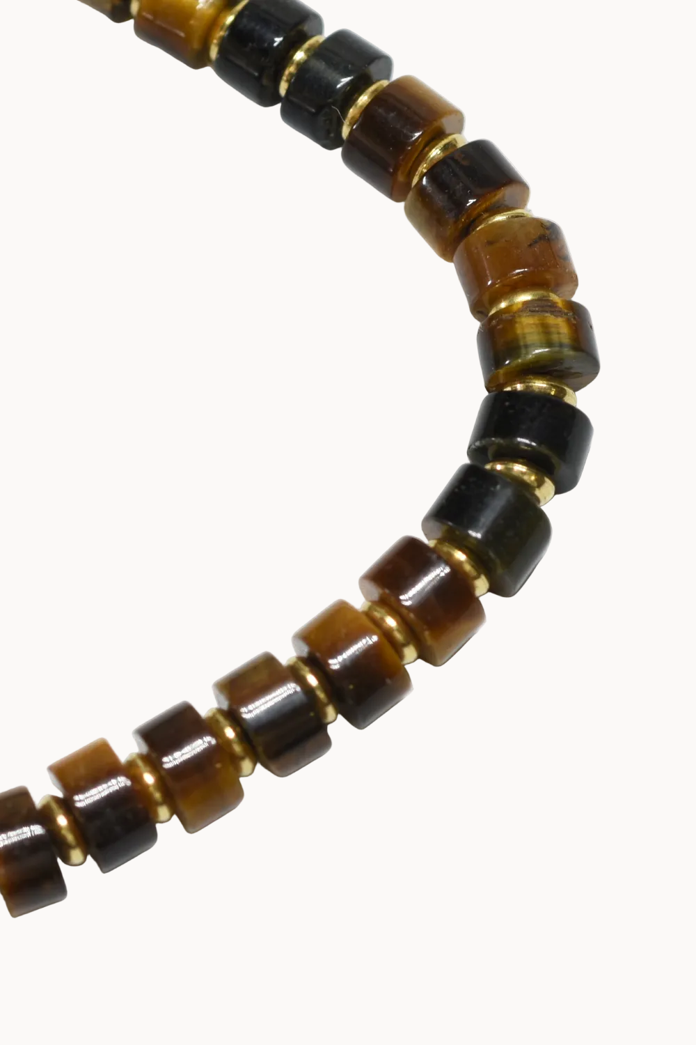 Close-up of a beaded necklace with brown and black beads on a white background