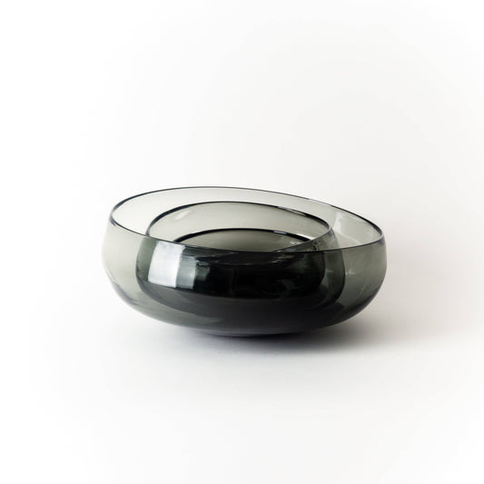 Three nesting smoky gray glass bowls on a white backgrounds