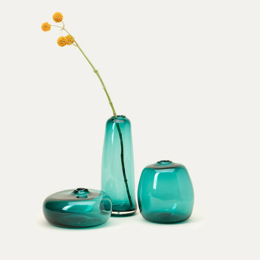 Three turquoise glass vases on a white background