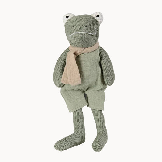 Knitted frog toy with a beige scarf on a white background