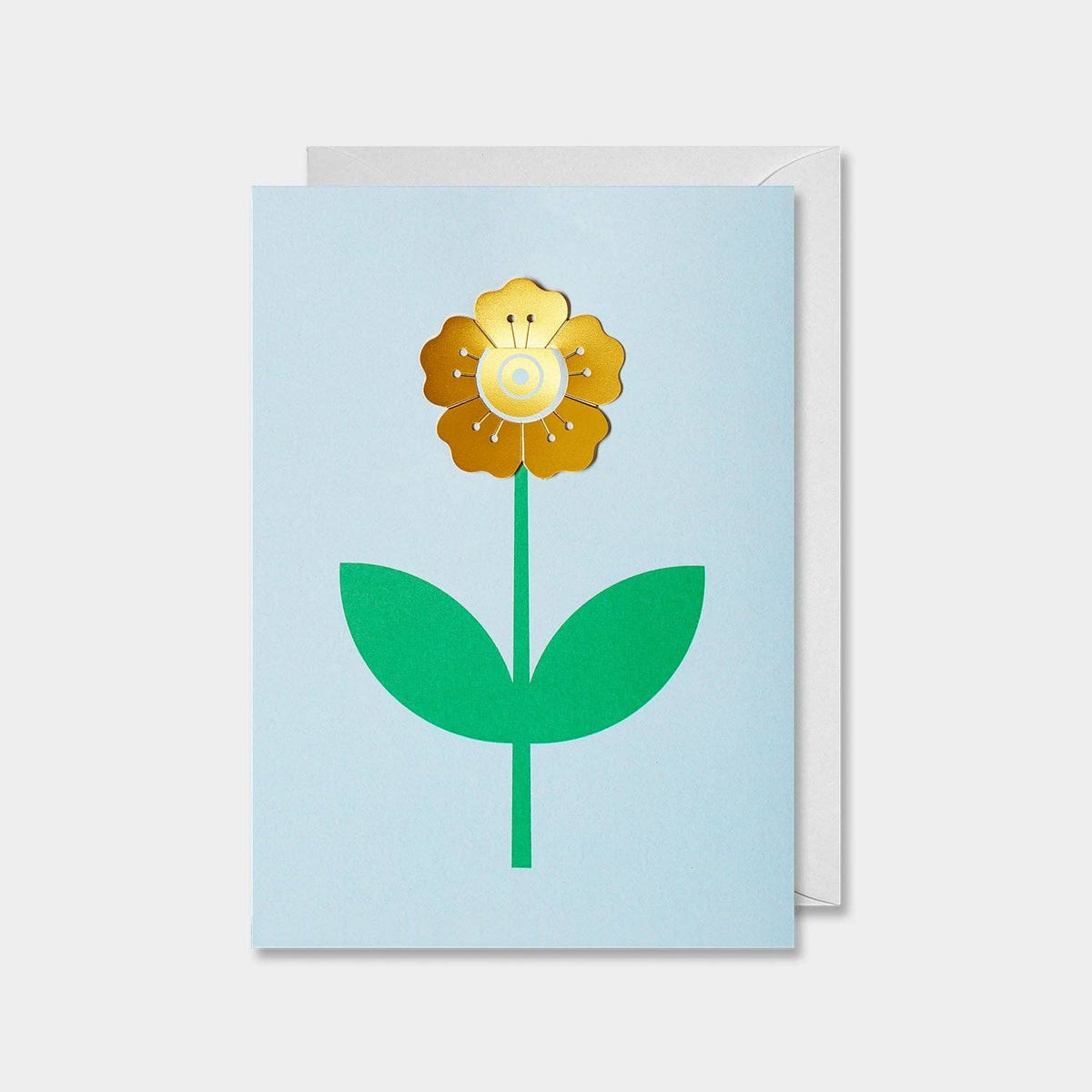 A greeting card with a colorful illustration of a flower with a sun in the center, green leaves, and a blue background. The card is blank inside and includes a white envelope.
