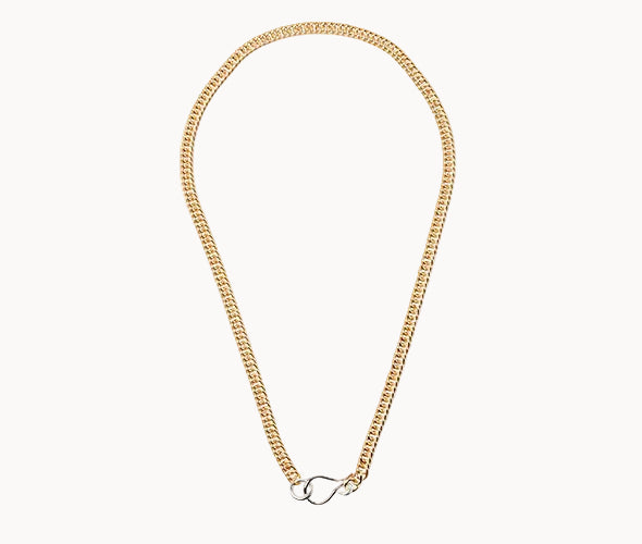 Gold chain necklace with a silver clasp on a white background